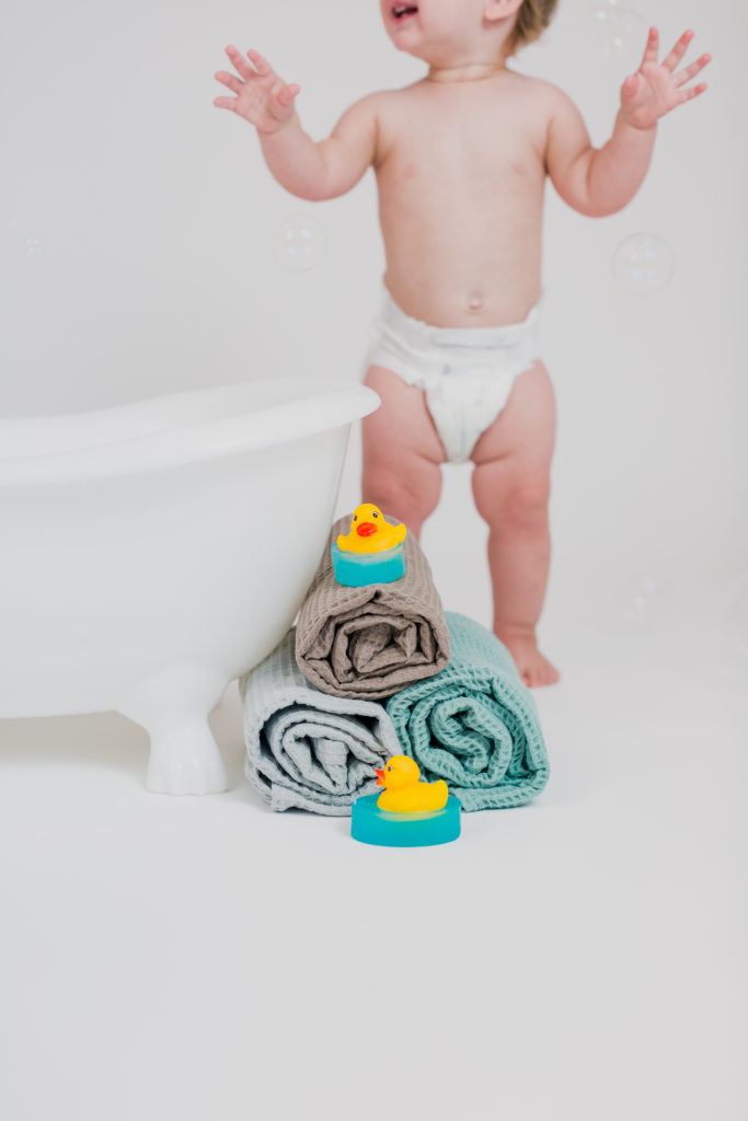 Baby Dancing Around Bath Towels and Duck Bath Soap Toys