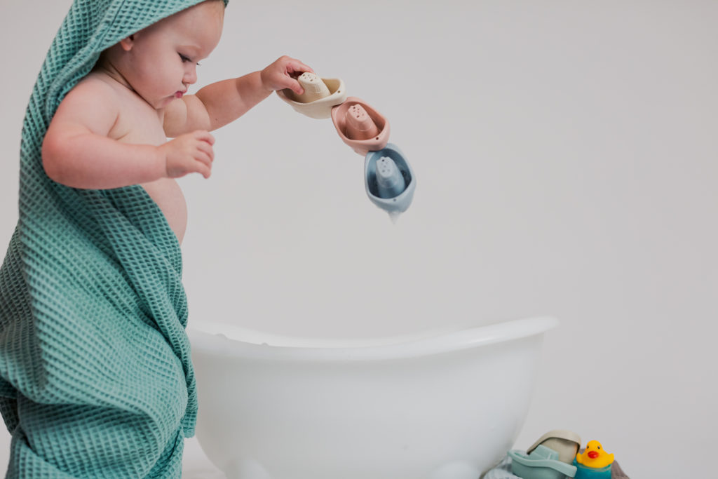 Baby Playing with Boat Bath Toys in Bath Towel