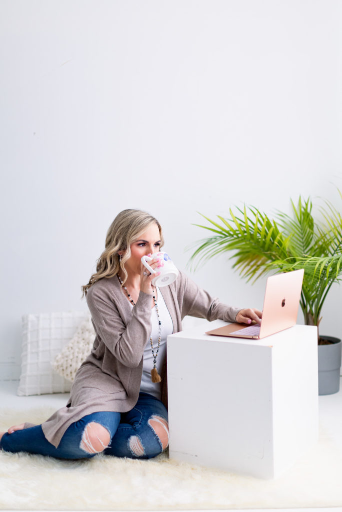 Woman Drinking Coffee and Working on a Rose Gold Laptop