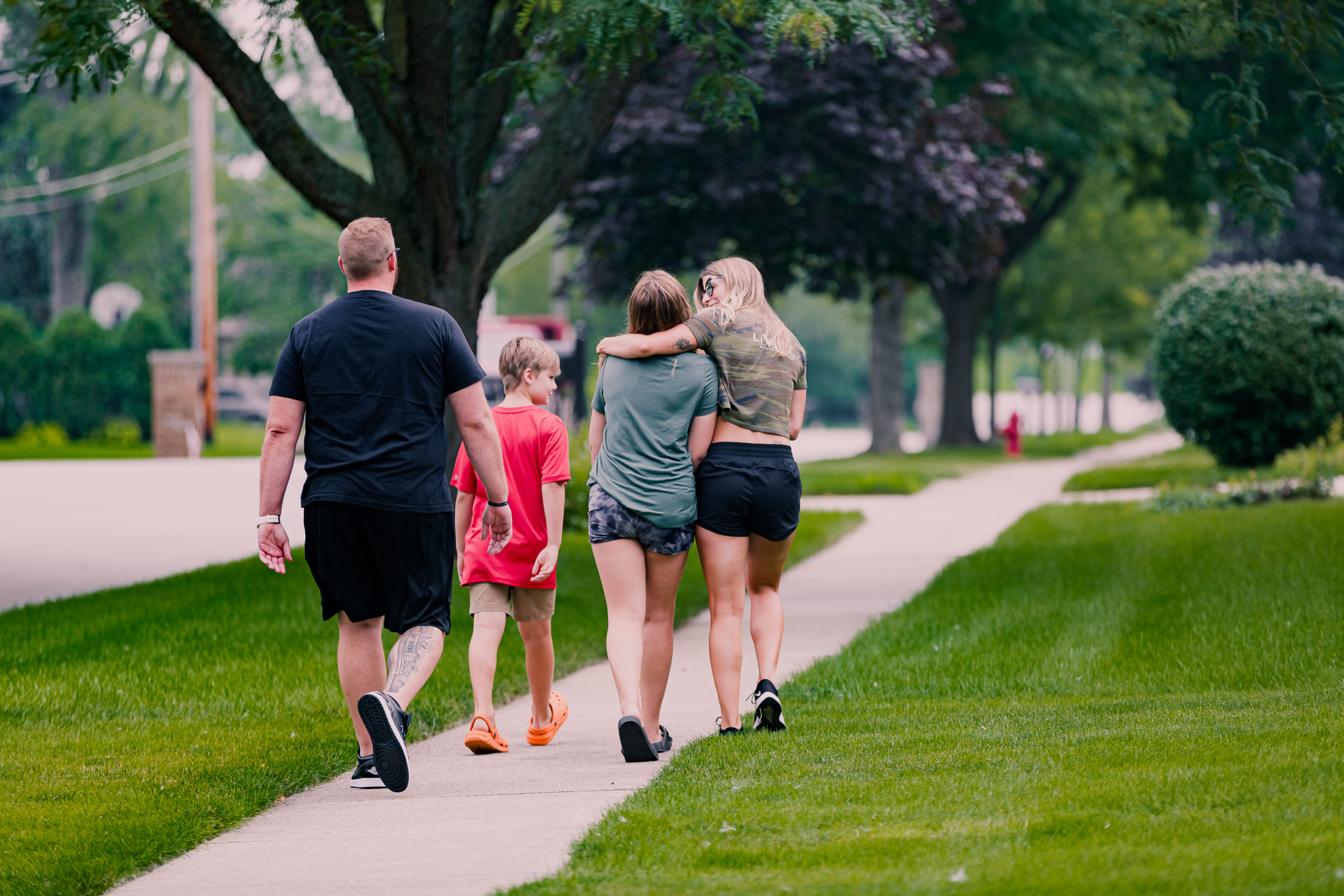 Loving Family Walking Away on Sidewalk