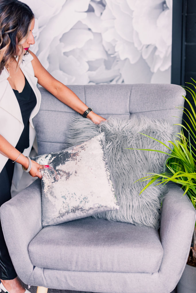 Woman Placing Decorative Pillows on Grey Chair