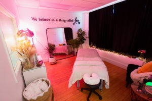 Massage studio lit in pink lighting