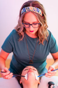 Woman giving a face massage to another woman