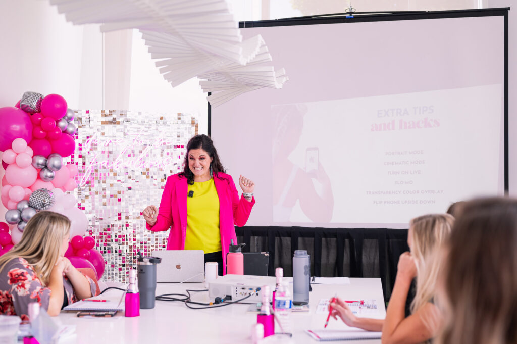 Jessi from This Way to Fabulous leading a branding seminar in a white and pink conference room