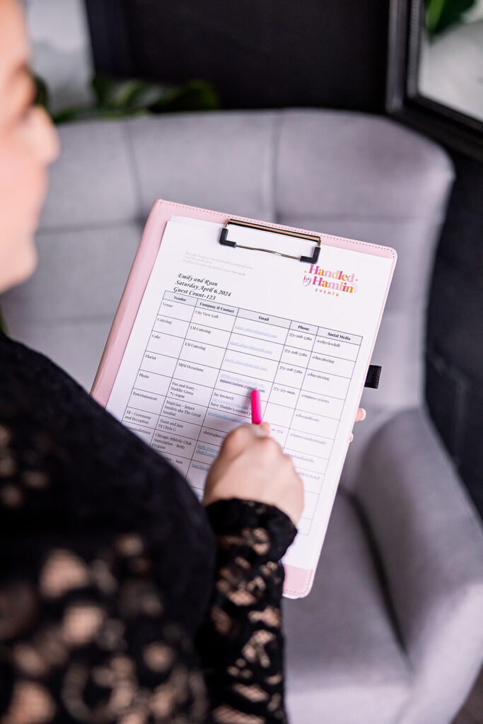 Vibrant brand photo of a woman in a black lace dress holding a clip board, taken by This Way to Fabulous