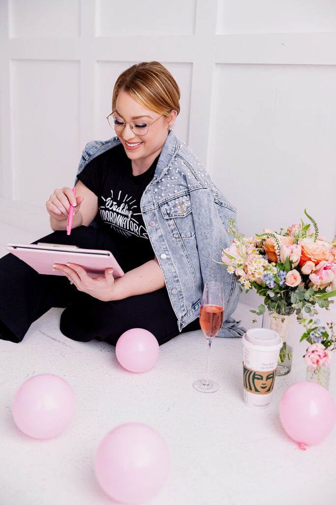 Vibrant and fun brand photo of a woman in a beaded jean jacket surrounded by flowers, balloons, and mood boards, taken by This Way to Fabulous