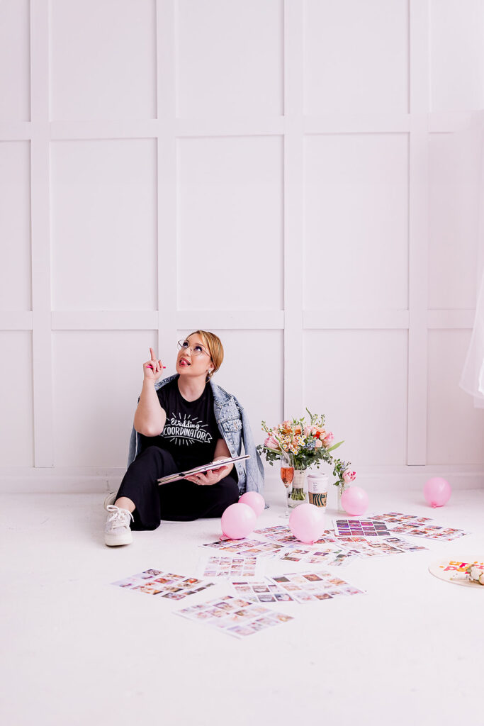 Vibrant and fun brand photo of a woman sitting surrounded by flowers, balloons, and mood boards, taken by This Way to Fabulous
