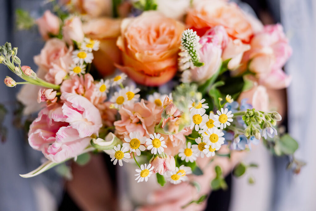 Vibrant and fun brand photo of a colorful bridal bouquet with roses and daisies, taken by This Way to Fabulous