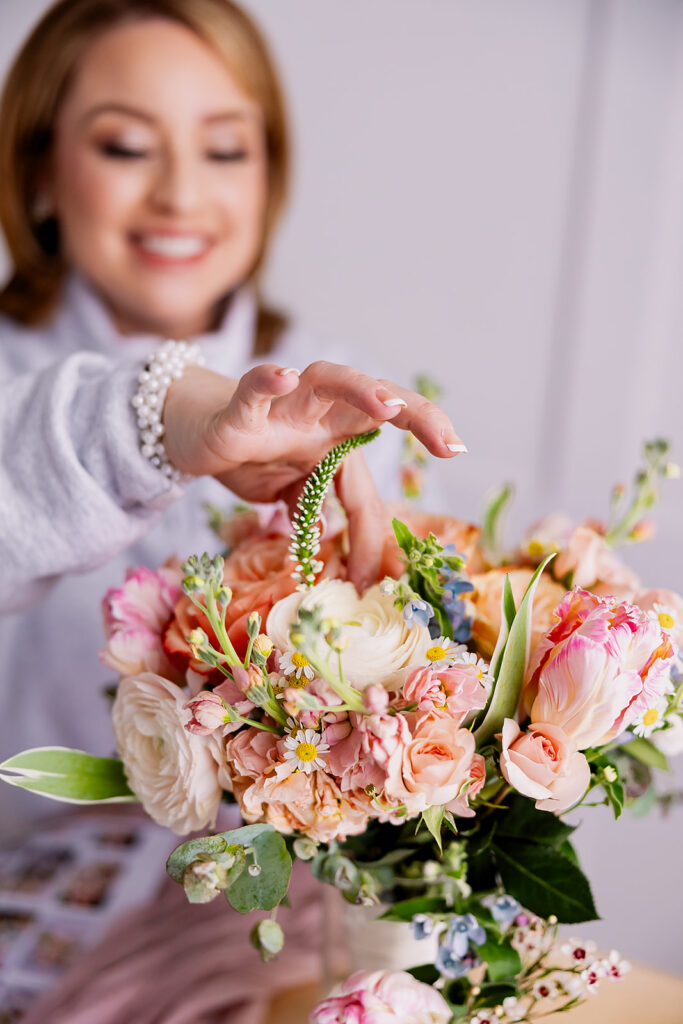 Vibrant and fun brand photo of a a woman arranging a bouquet of flowers, taken by This Way to Fabulous