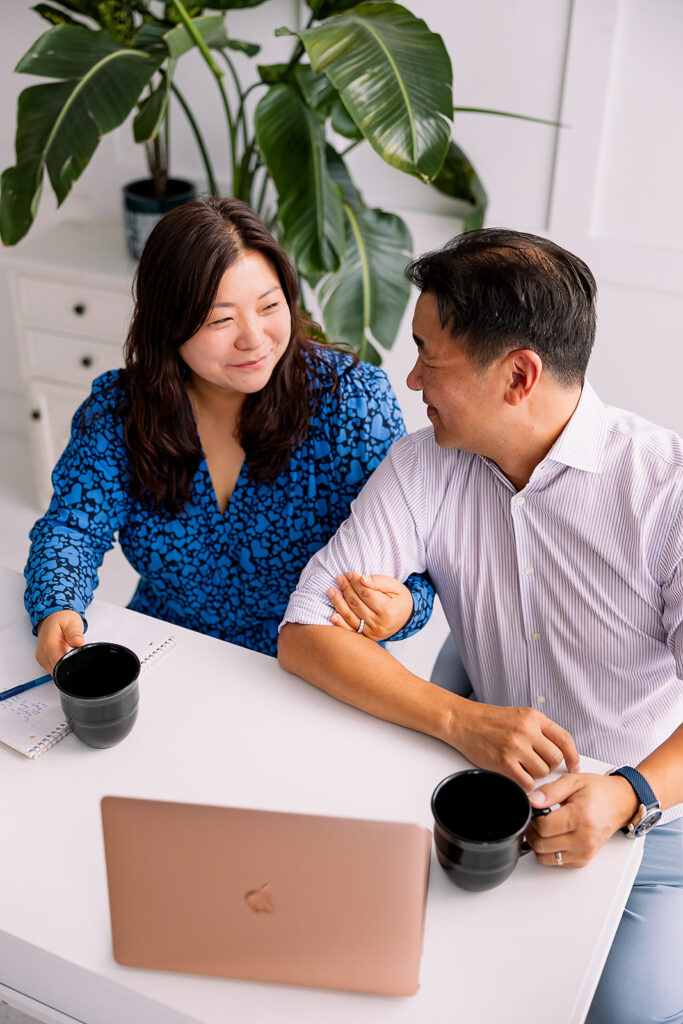 two people embracing and sitting at a desk holding coffee cups