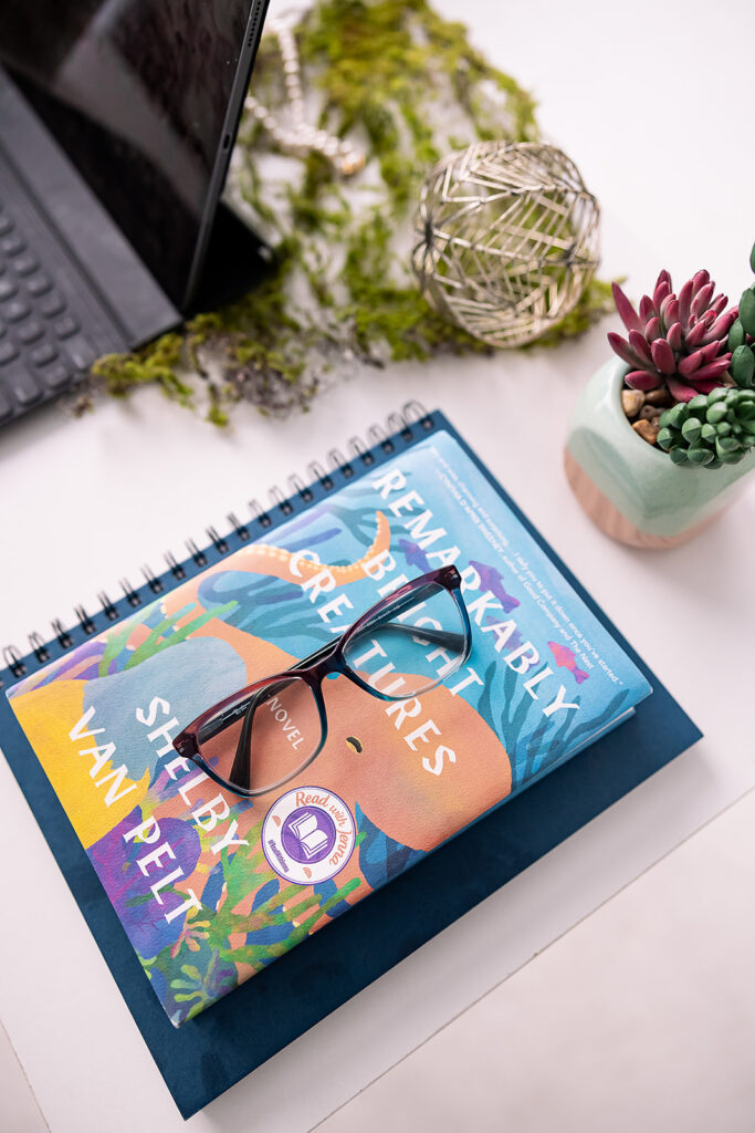 stack of books with glasses on a desk