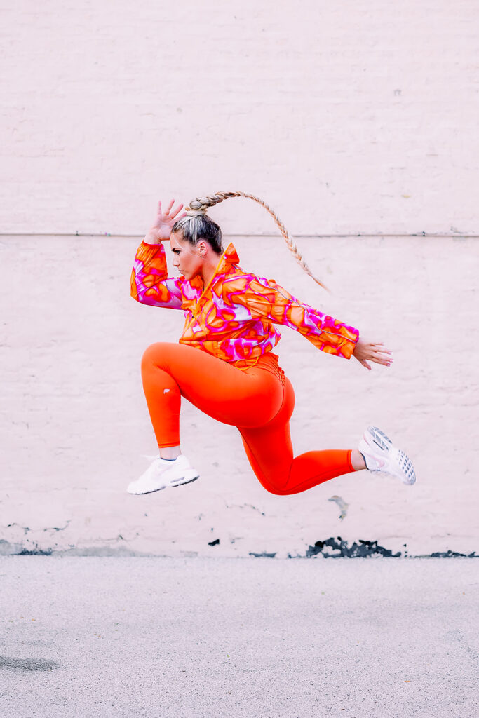 fitness instructor jumping in bright colorful clothes