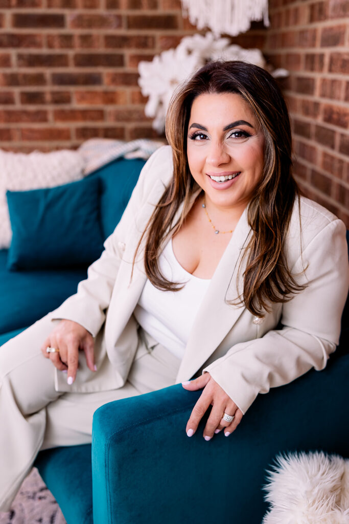 a woman in a cream suit smiling at the camera