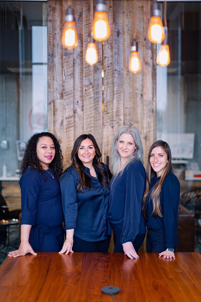 real estate agent team in navy blue standing by their office conference table