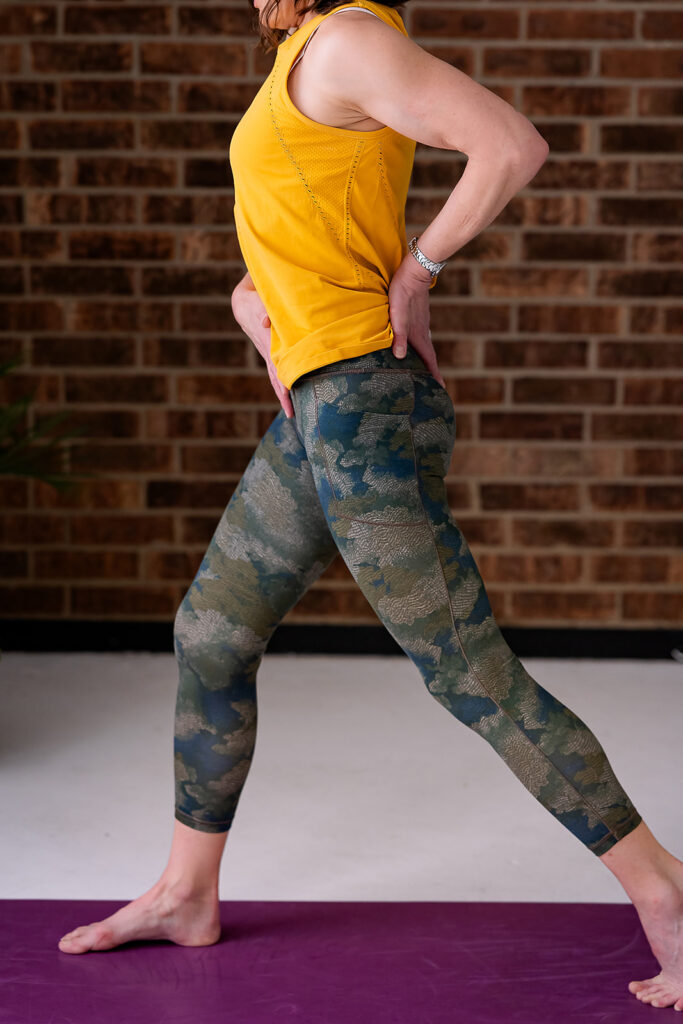 a woman dressed in workout clothing in a fitness branding photo on a yoga mat