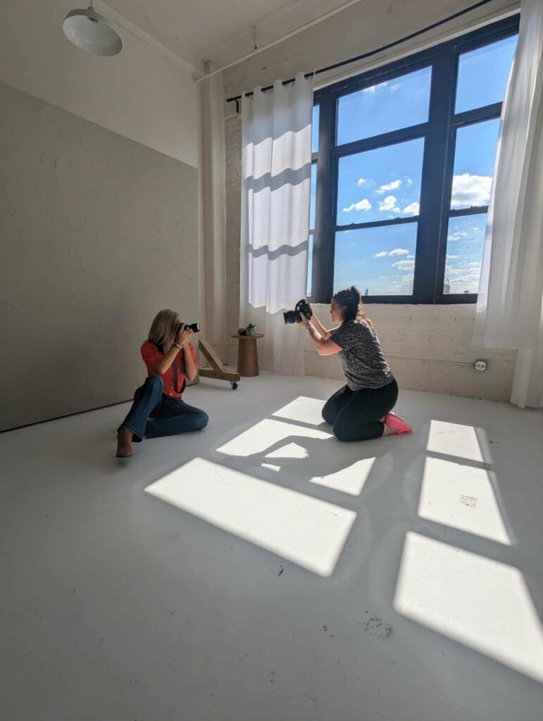 two photographers taking photos of each other during a branding photoshoot