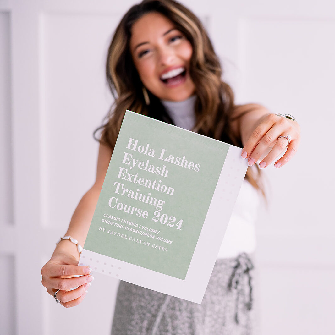 a woman holding a pamphlet for her eyelash extension business