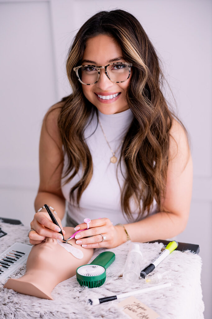 Branding detail image of a brunette woman doing lash extensions on a dummy