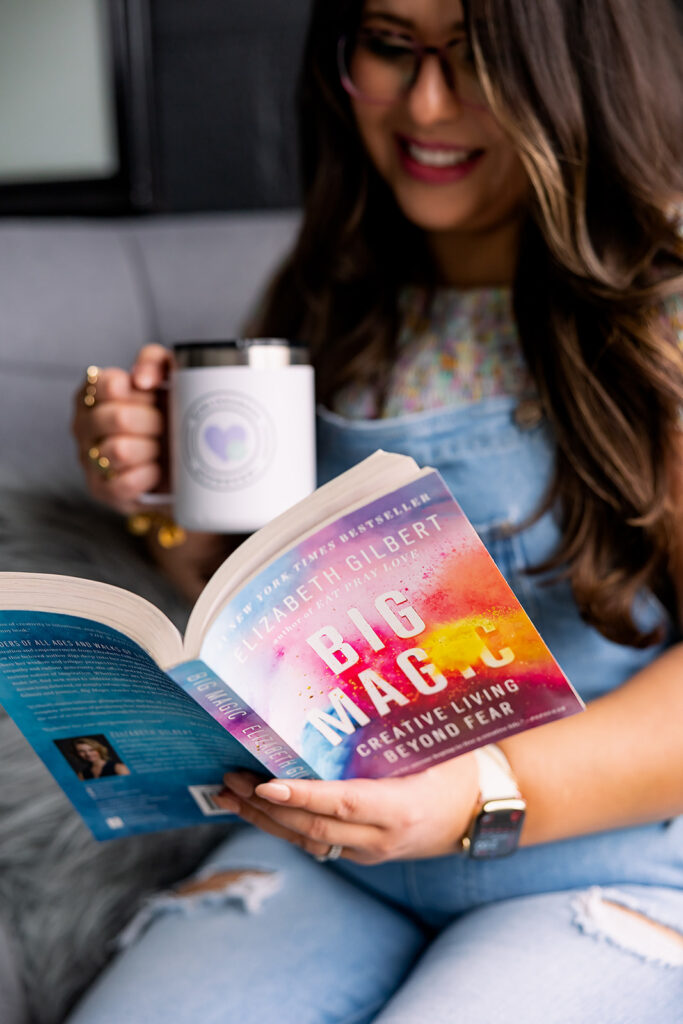 personal branding photo of Jacquelin Castillo of Mom Like a Boss reading Big Magic and holding a coffee mug, photographed by This Way to Fabulous