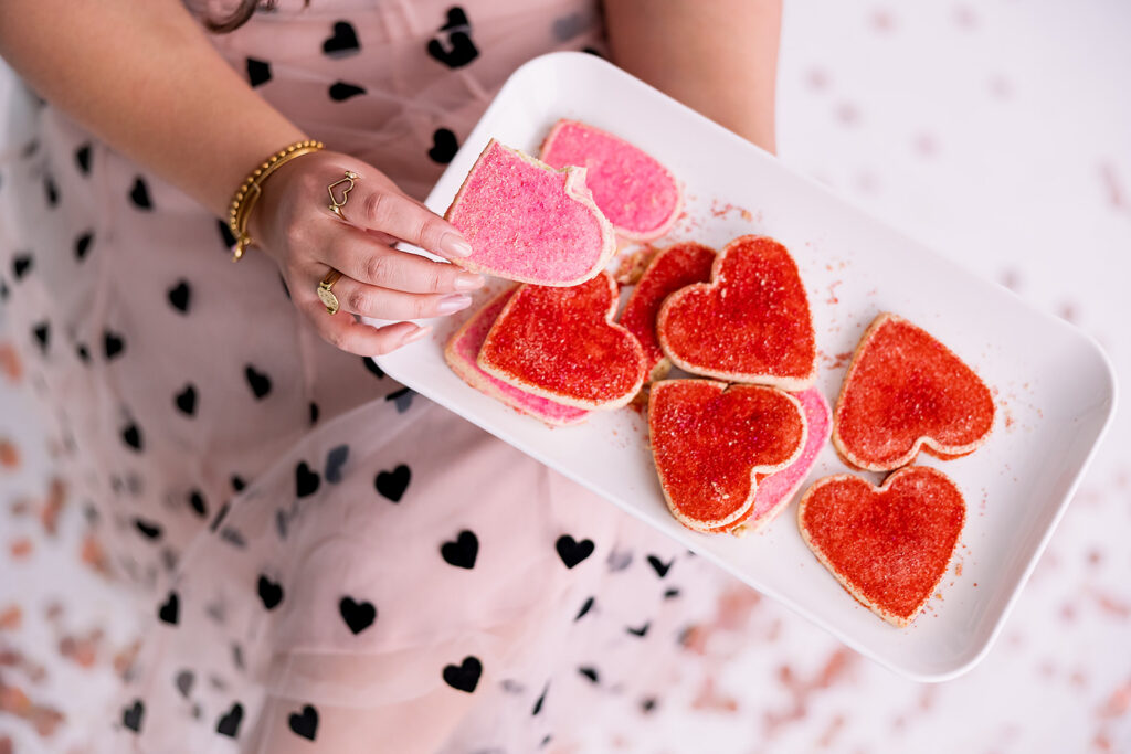 personal branding photo of Jacquelin Castillo of Mom Like a Boss holding pink and red sugar cookies photographed by This Way to Fabulous