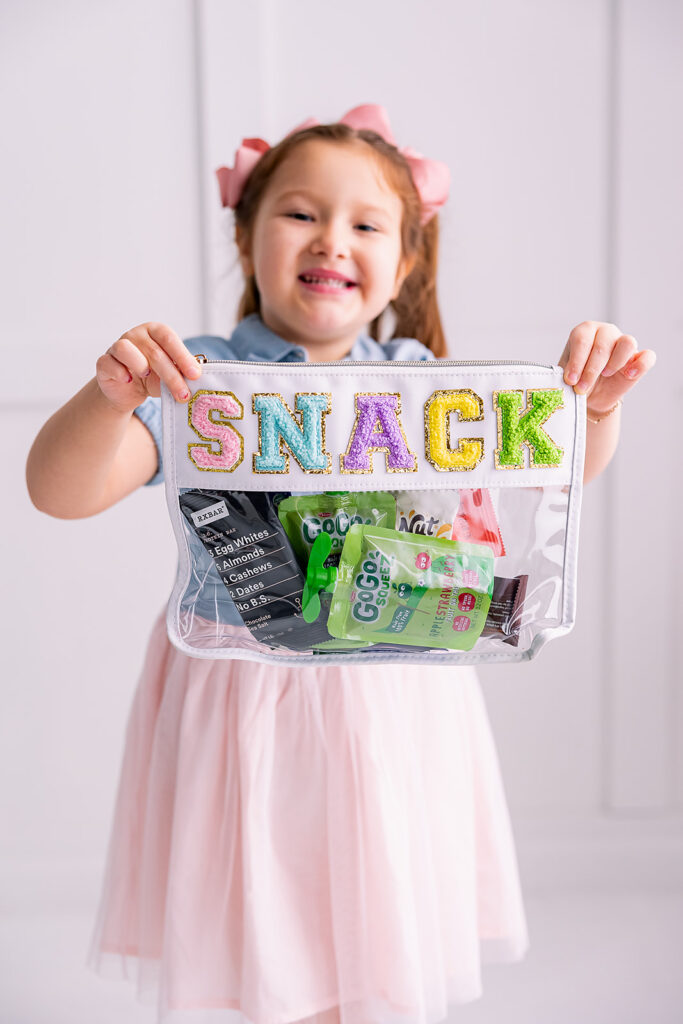 personal branding photo of Jacquelin Castillo's daughter of Mom Like a Boss holding a colorful branded snack bag photographed by This Way to Fabulous