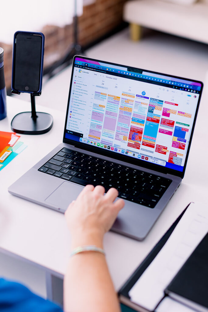 a computer with a heavily packed calendar showing on screen during a professional organizer branding photoshoot by This Way to Fabulous